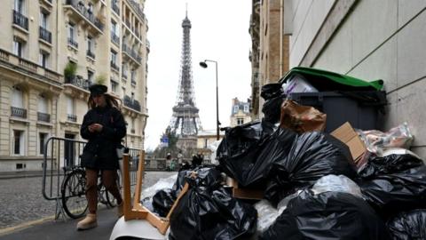 Garbage cans overflowing with trash on the streets as collectors go on strike in Paris, France on March 13, 2023. Garbage collectors have joined the massive strikes throughout France against pension reform plans.