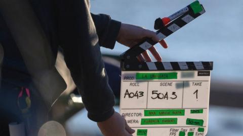 An assistant holds the clapperboard during the shooting of La Uruguaya film in Montevideo on October 19, 2021