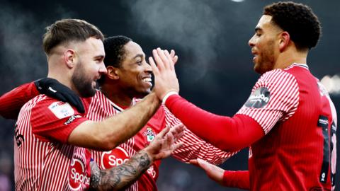 Adam Armstrong (left) celebrates a goal with Kyle Walker-Peters and Che Adams (right)