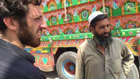 Noor Mohammad, right, beside a truck