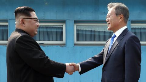 North Korean leader Kim Jong-un (left) and South Korean President Moon Jae-in pose for photos in front of Peace House in Panmunjom, South Korea, 27 April 2018