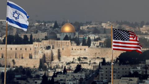 Israeli and US flags fly from the roof of an Israeli settlement building in East Jerusalem