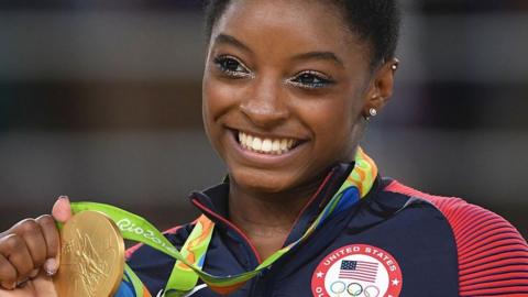 Simone Biles holds Olympic Gold medal