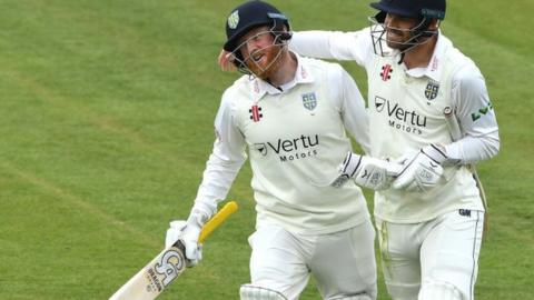 Jack Burnham was congratulated by Stuart Poynter (right) after making his first century for Durham in five years