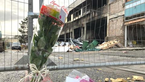 Flowers left at the scene of the explosion and fire on the Treforest Industrial Estate