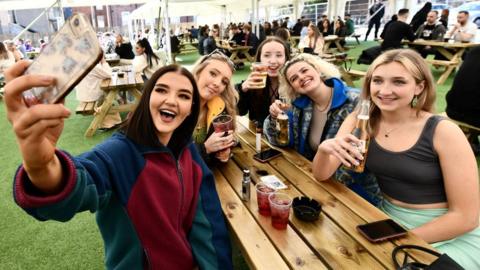 Young women enjoying drinks at an outdoor bar in Belfast