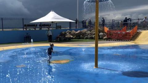 Child playing in a splash pool