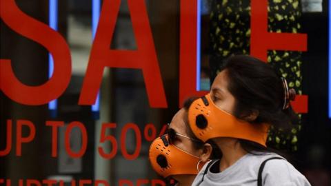 Women in masks outside shop