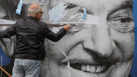 Activists of opposition party removes a government billboard in Budapest