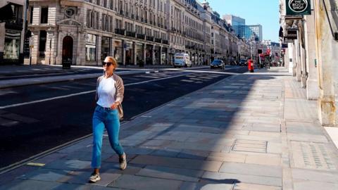 Woman in an otherwise deserted Regent St, London