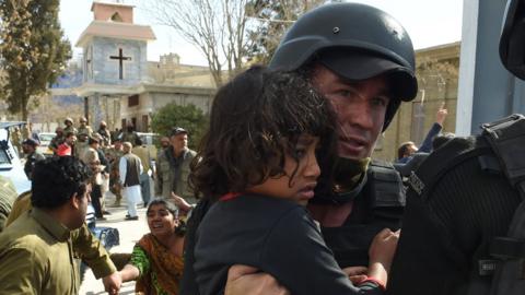 A young girl is carried away from the church by security personnel after the attaci in Quetta (December 17 2017)