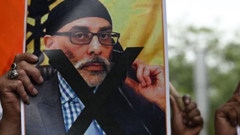 A member of United Hindu Front organisation holds a banner depicting Gurpatwant Singh Pannun, a lawyer believed to be based in Canada designated as a Khalistani terrorist by the Indian authorities during a rally along a street in New Delhi on September 24, 2023. In an interview with an Indian news channel, Pannun said Nijjar had been his "close associate" for over 20 years and was like a "younger brother" to him. He also blamed India for Nijjar's killing. A diplomatic firestorm erupted this week with Canadian Prime Minister Justin Trudeau saying there were "credible reasons to believe that agents of the government of India were involved" in Nijjar's death. (Photo by Arun SANKAR / AFP) (Photo by ARUN SANKAR/AFP via Getty Images)