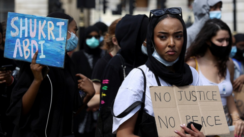 demonstrators hold placards