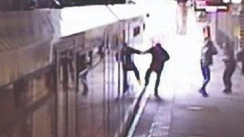 Man with hand caught in tram door