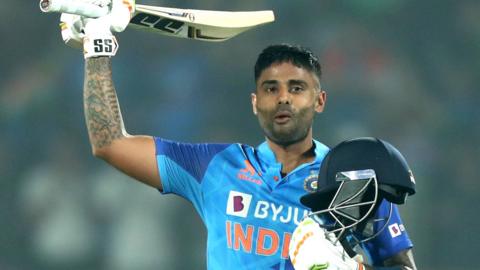 India batter Suryakumar Yadav raises his bat in celebration after hitting a century in a T20 against Sri Lanka