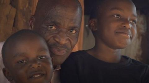 Father with two kids outside their home in Kibera