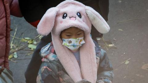 Kid in China wearing face mask after WHO asks Beijing to explain pneumonia clusters