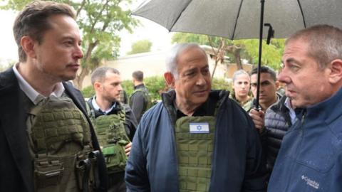 Elon Musk (left) and Prime Minister Benjamin Netanyahu tour the kibbutz Kfar Aza (Government Press Office of Israel handout)