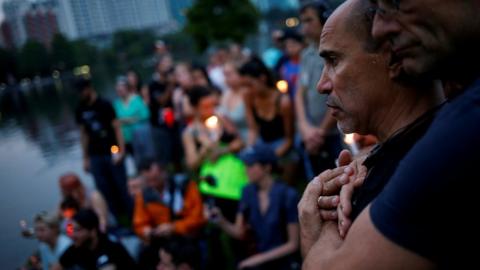 Wilfredo Perez (L), a local bartender at a gay bar, is embraced by his partner Jackson Hollman during a vigil to commemorate victims of a mass shooting at the Pulse gay night club in Orlando, Florida, 12 June 2016