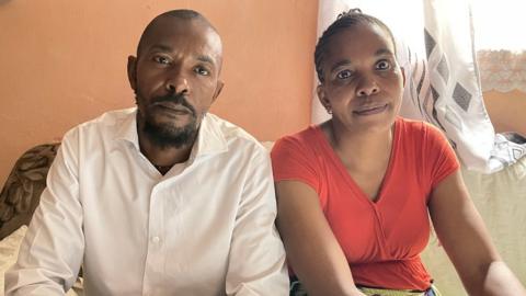 A man and a woman looking into the camera