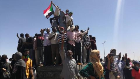 Demonstrators waving flags and shouting outside the army headquarters on March 6