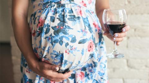 Pregnant woman holding a wine glass