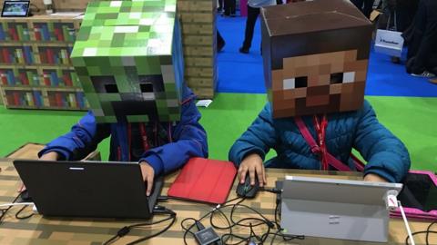 Kids on computers with Minecraft heads