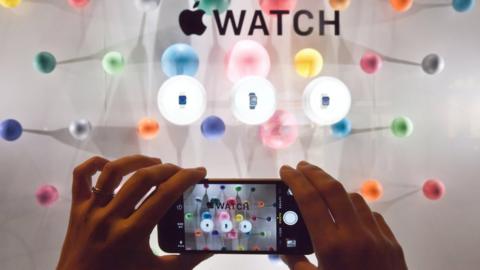 A woman photographs a window display of the Apple watch during the unveiling of the new and highly anticipated product at Saint-Honore street in Paris