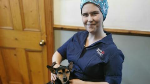 Dr Kiah Hann sitting in a wheelchair with a dog