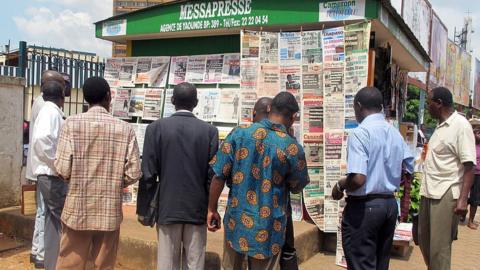 People look at newspapers featuring portraits of Cameroon's president at a newsstand in Yaounde