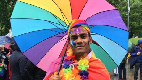 A Pride visitor holding an umbrella