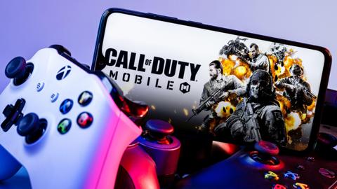 An xbox controller and mobile phone showing Call of Duty