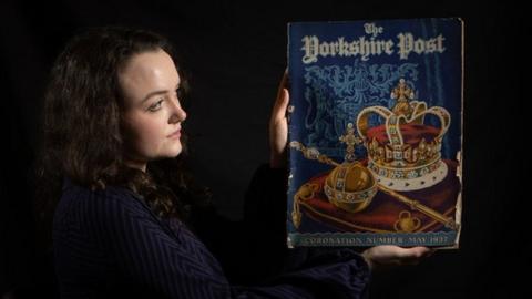 A woman holds up a Yorkshire Post item