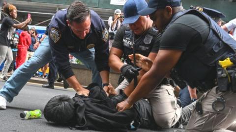 Police officers hold down a person