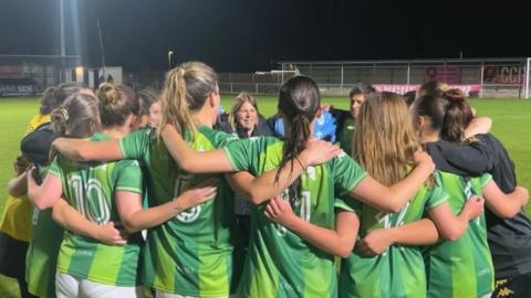 Guernsey FC women in a huddle after their win