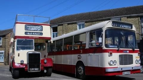 Two red and white vintage buses