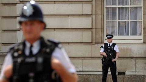 Stock image of police officers in front of Buckingham Palace