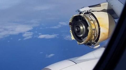A photo shows the view form a plane in mid-air, with a severely damaged engine clearly visible, with parts missing and substantial metal damage
