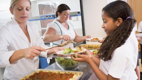 Pupils being served dinner