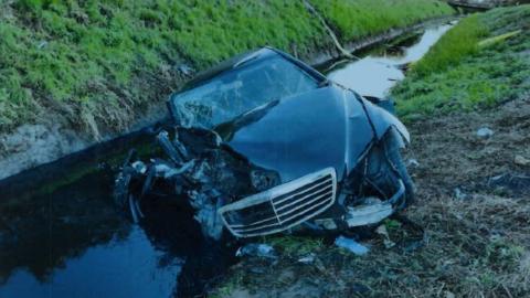 Crashed car in a ditch with water