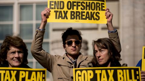 People protest the Republican tax reform plan outside the Department of Commerce on November 10, 2017 in Washington, DC