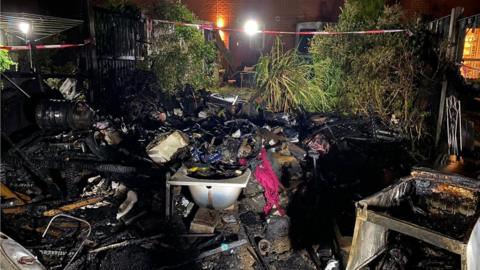 Fire-damaged garden in Greenwood Close