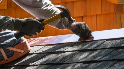 Stock image of a roofer working.