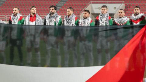 Palestine football team hold flag up