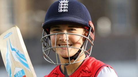 Alice Capsey smiling while batting in an England training session