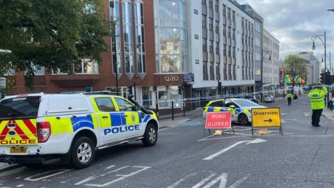 Queens Road with police cars, officers and tape