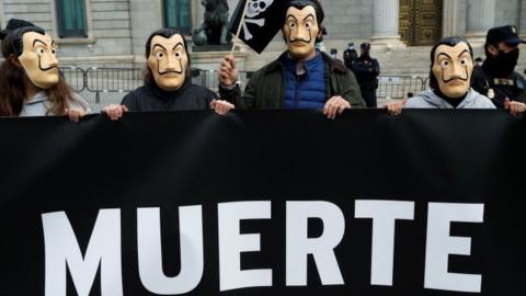 Protesters outside Spain's parliament in Madrid show part of a banner with the word "death". Photo: 17 December 2020