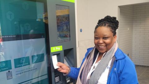 Debra Leso buys a ticket from a self-service machine