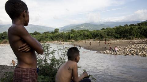 Children play in the river at the border of Columbia and Venezuela