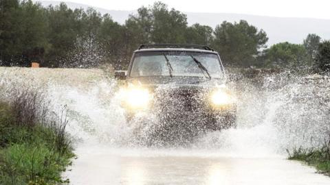 Car driving through water on a road